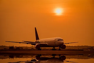 Shutterstock : A airplane lands on an offshore platform at sunset