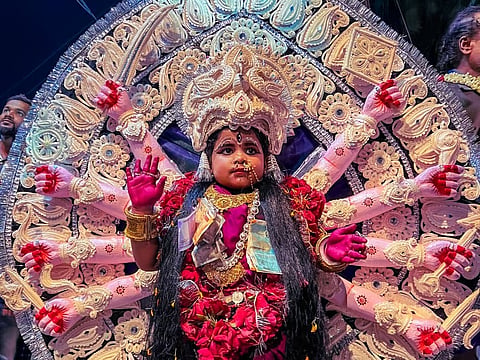 A child portraying Goddess Durga, adorned in an elaborate Durga Medha made of handcrafted Shola Pith