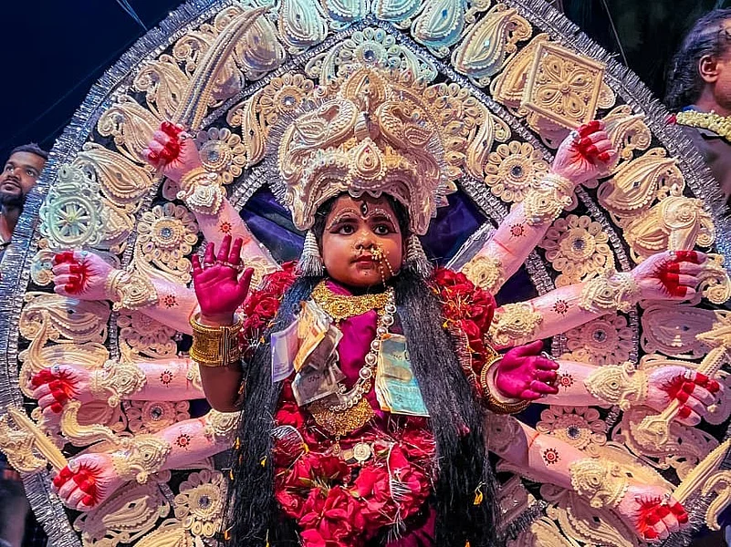 A child portraying Goddess Durga, adorned in an elaborate Durga Medha made of handcrafted Shola Pith