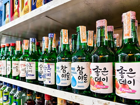 A colourful display of Korean soju bottles on store shelves