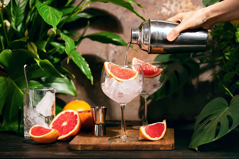 A mixologist prepares a pink grapefruit and rosemary gin cocktail (representative only) - Shutterstock
