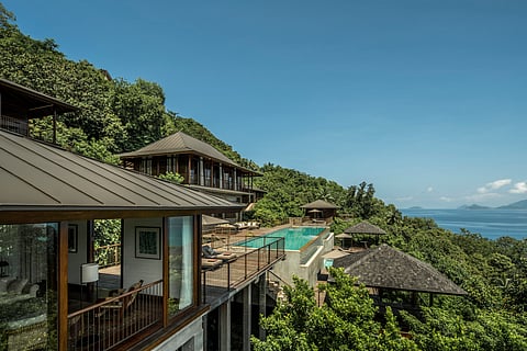 Villas sit at different elevations, partly screened by tropical plants and granite boulders.