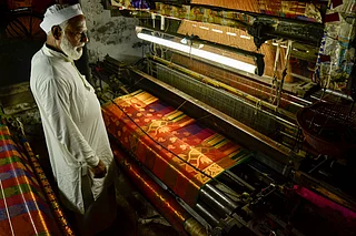 Shutterstock : A weaver in Varanasi crafts the Banarasi sari on his handloom weaving machine