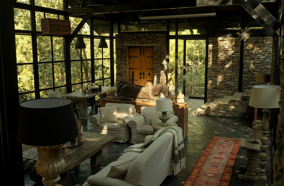 The lounge at The Sen, with stone walls, glass, wood and forest views