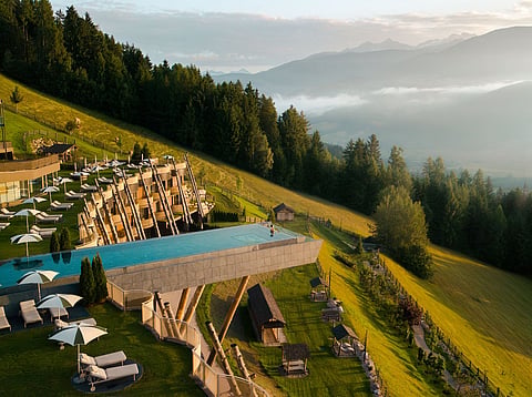 Hotel Hubertus pairs alpine architecture with a cantilevered pool overlooking the Dolomites