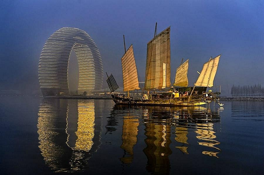The Moon Hotel rises above Taihu Lake in a striking elliptical form