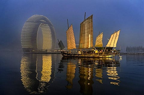 The Moon Hotel rises above Taihu Lake in a striking elliptical form