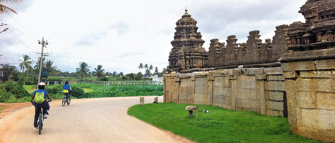Cyclists ride throught the Nandi Village