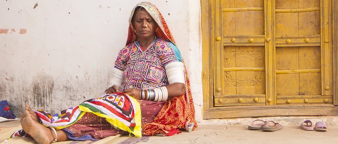 A traditional woman working on an ethnic embroidered cloth