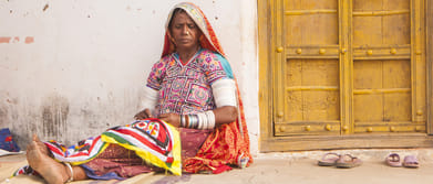 A traditional woman working on an ethnic embroidered cloth