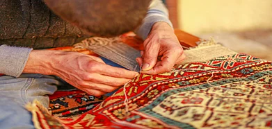 Shutterstock : An artisan weaves dhurrie rug by hand