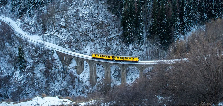 Little Yellow Train travelling in winter, in Mont-Louis, Pyrenees-Orientales, France. - Shutterstock