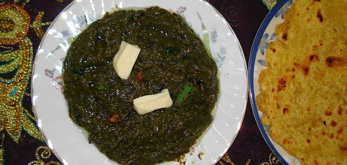 Sarso ka saag is a mix of seasonal greens like mustard leaves, radish leaves, spinach and bathua or pigweed and is best enjoyed with makki ki roti (cornmeal flatbread) and white butter. Credit Wikimedia commons