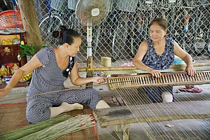 Women making tatami mats with grass in Vietnam Michael Habana Coronel / Shutterstock