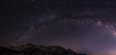 Sky covered with stars above the ice capped mountains