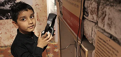 A child listening to an audio-visual presentation at the Partition Museum