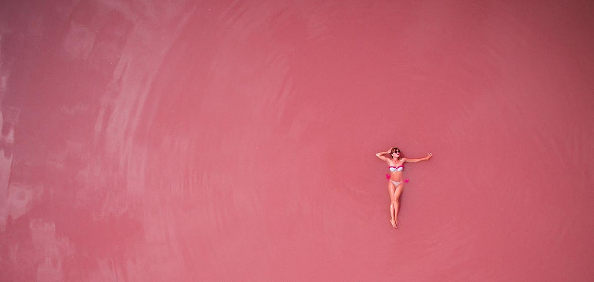 A tourist swimming in Australias pink Lake Hillier