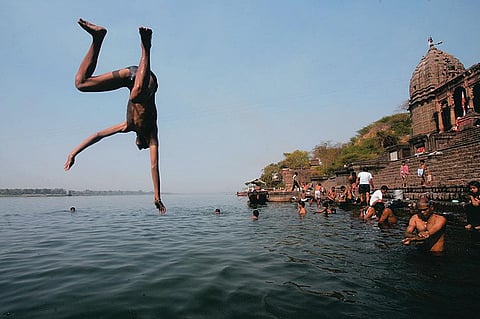 A boy leaps into the Narmada near the Shiva temple on Maheshwar's ghats