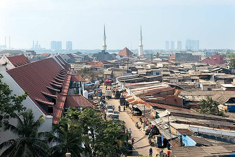 The view from the watch tower with the village of Luar Batang and its mosque in the foreground