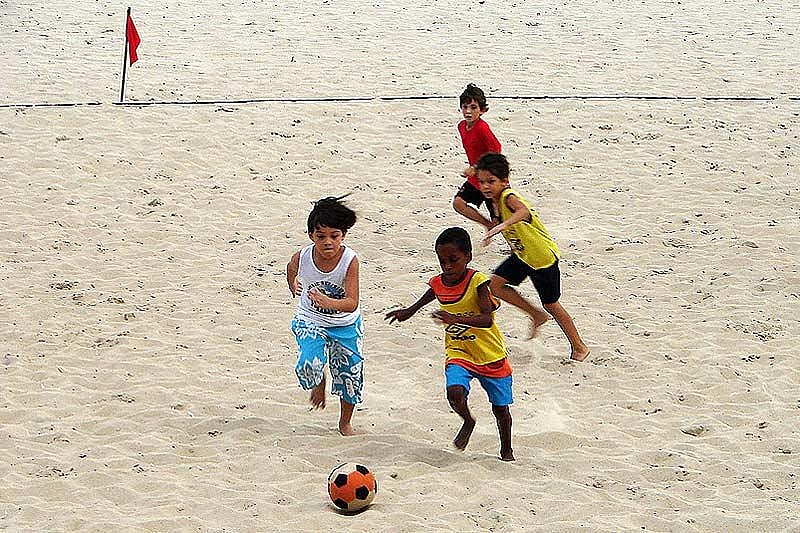 Little football fanatics playing the game at a beach in Brazil
