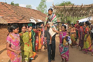 Women dance in a circle as the bride is carried on her fathers shoulder