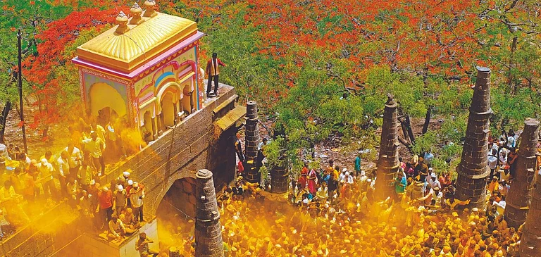 Devotees throw turmeric as an offering to Lord Khandoba at the Jejuri temple, Maharashtra - Shutterstock