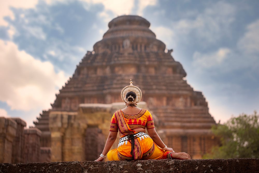 An Odissi dancer poses in front of the Sun Temple. Credit Shutterstock