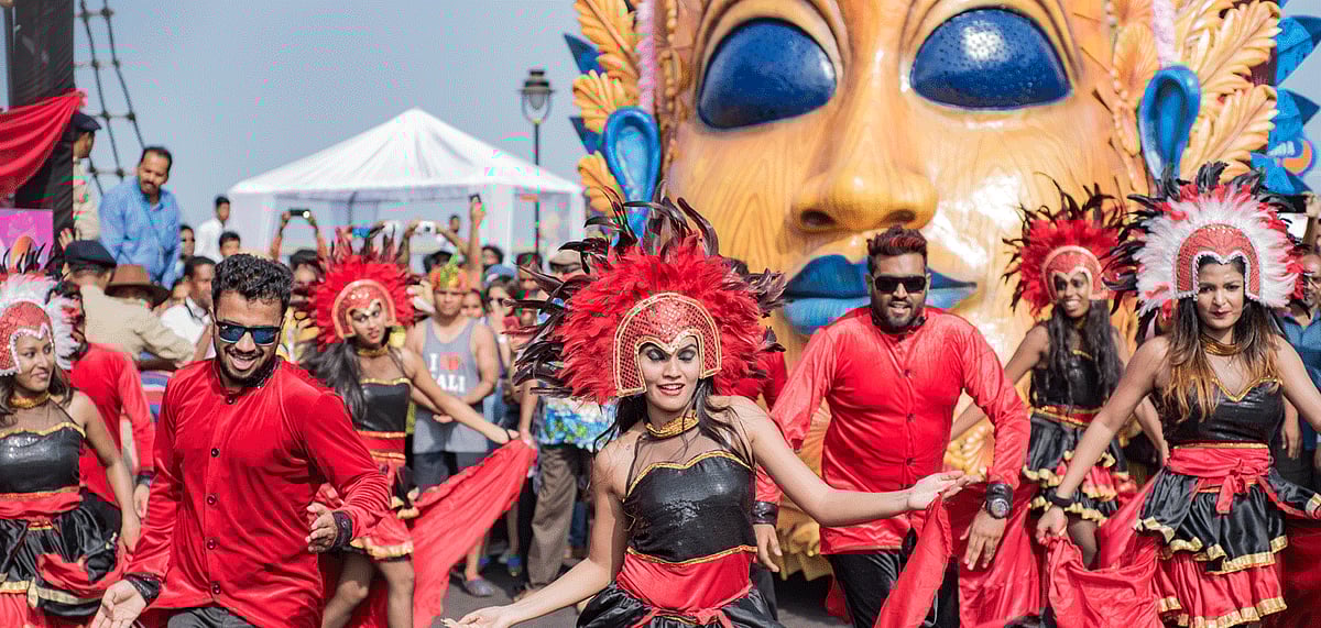 People celebrating at the Grand Parade, dancing in the streets with feathers and masks