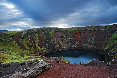Kerid, a volcanic crater lake along the route to the popular Golden circle is easily recognisable by its striking red volcanic rock and aquamarine water
