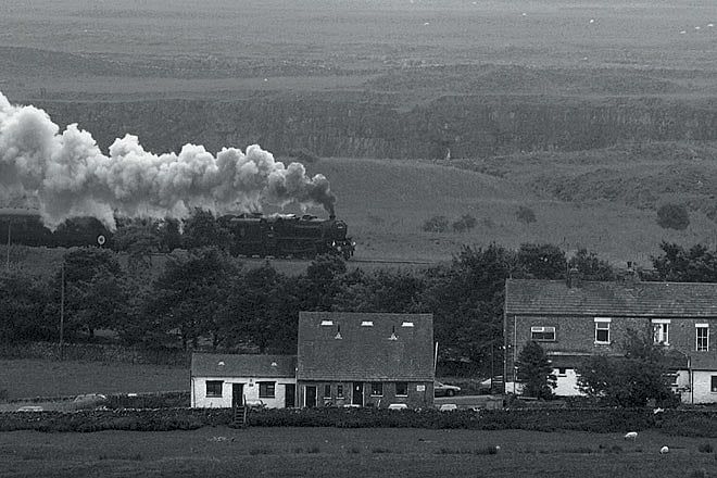 A steam train chugging through the countryside on its way to the Ribblehead viaduct