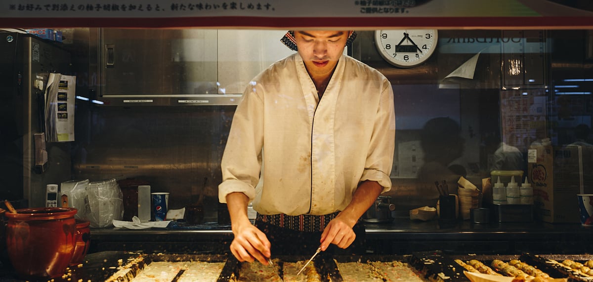 A chef makes takoyaki at a food stall in Tokyo train station
