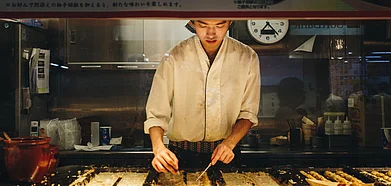 A chef makes takoyaki at a food stall in Tokyo train station