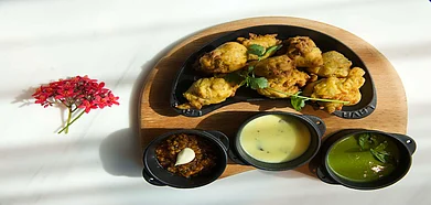 Deep-fried bhajiyas with an assortment of chutneys and Gujarati kadhi