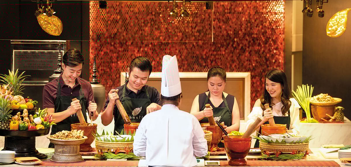 Guests trying to cook a traditional Thai dish 