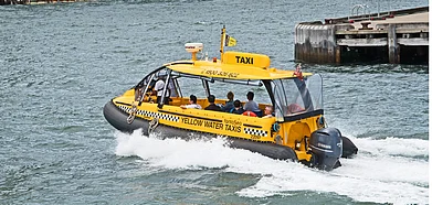 A yellow water taxi laden with passengers