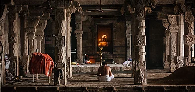 A priest sits alone and offers prayers