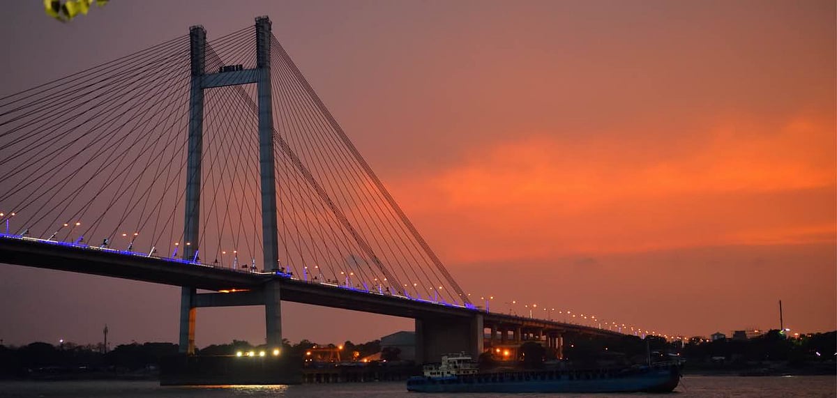 A silhouette of Vidyasagar Setu over the river at dusk