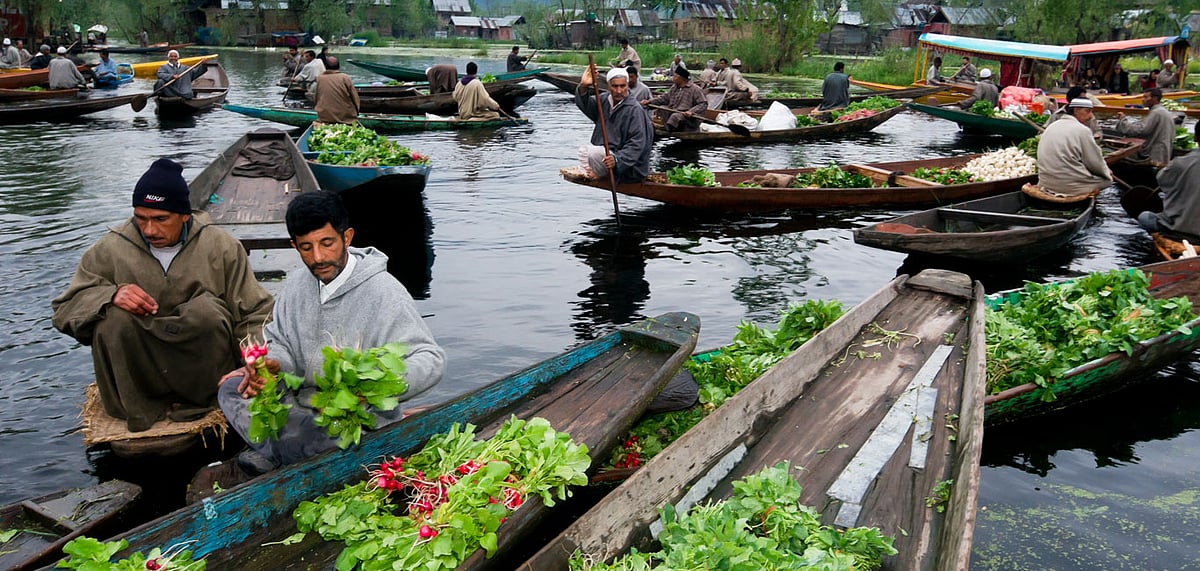 Kashmiri men sell their vegetables at a floating market