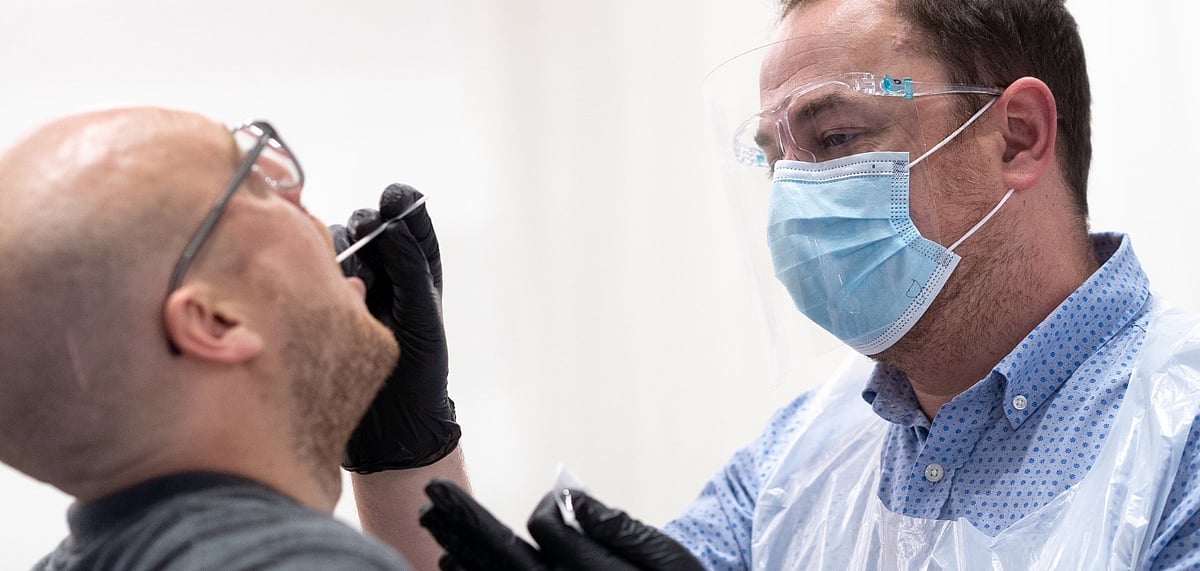 A doctor performing a COVID-19 test on a British Airway passenger 