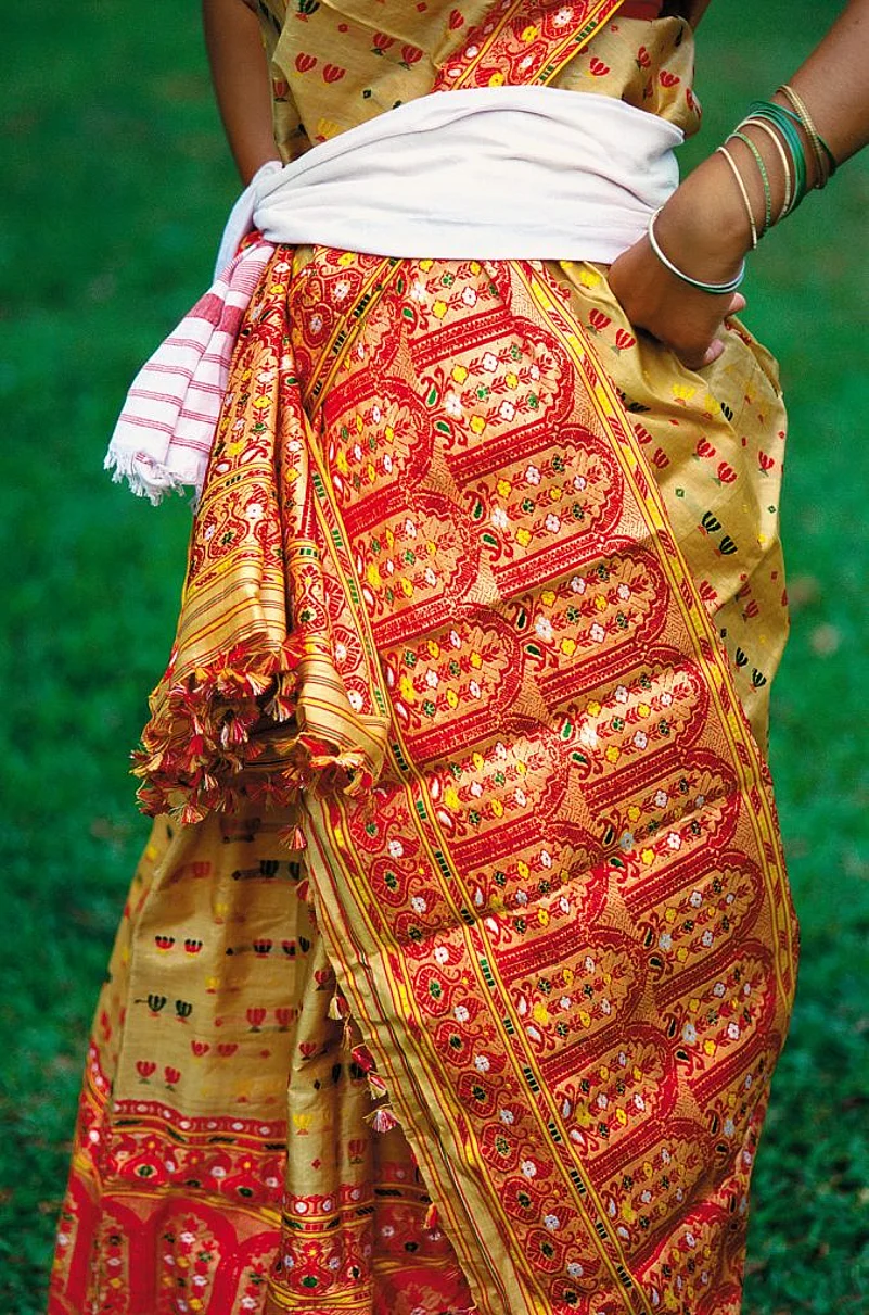 Mekhela chadars made from muga are gracefully draped by dancers during Rongali Bihu