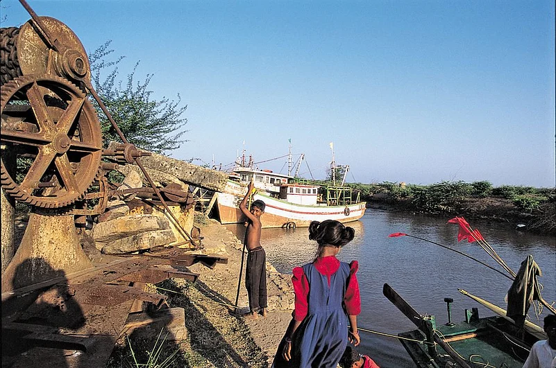 Kids play by a creek where trawlers park