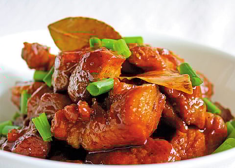 Bite into pork belly adobo