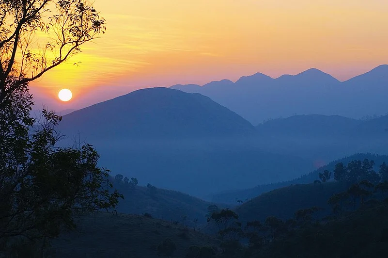 The sun rises over mist-covered hills in Vagamon.