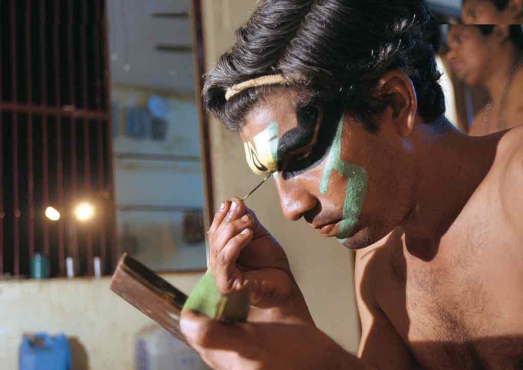 An artist puts on makeup before a performance