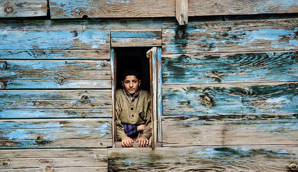 A boy peaks out in Kullan village