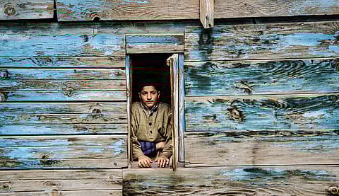 A boy peaks out in Kullan village