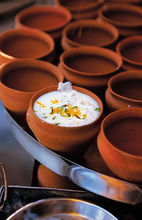 An earthen glass filled to the brim with delicious, creamy lassi 