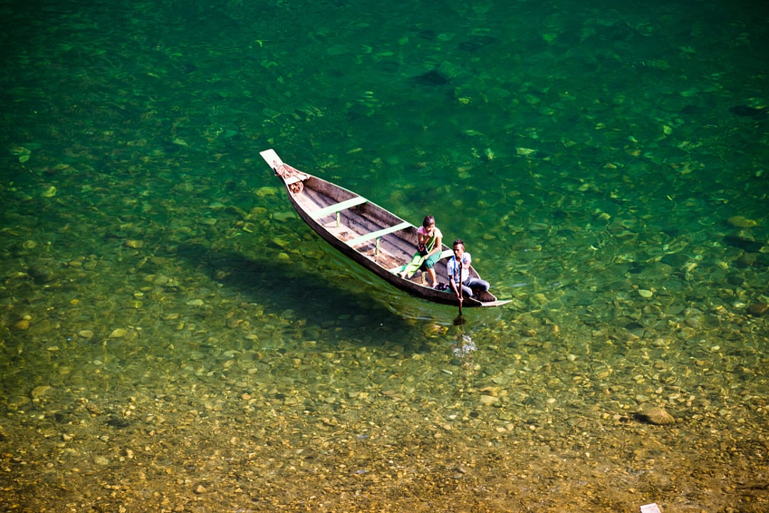 Fishermen ply boats on the Umngot