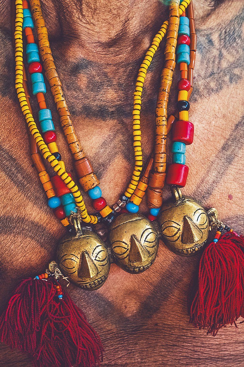 The tattooed headhunters wearing beads and brass necklaces