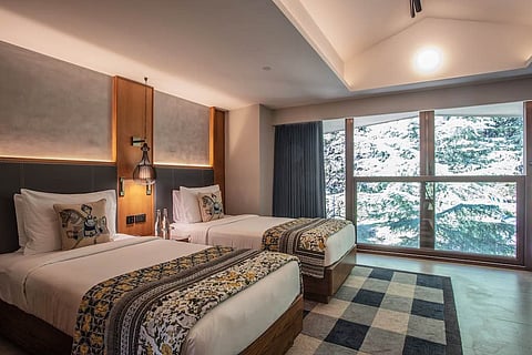 The mesh door of the hotel room gives a stunning view of the blue mountain.